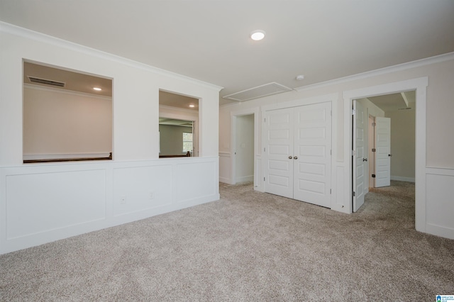 unfurnished bedroom featuring a closet, light carpet, and crown molding