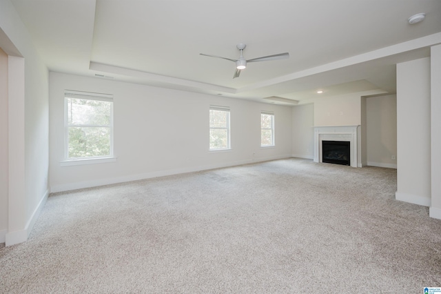 unfurnished living room featuring light colored carpet and ceiling fan