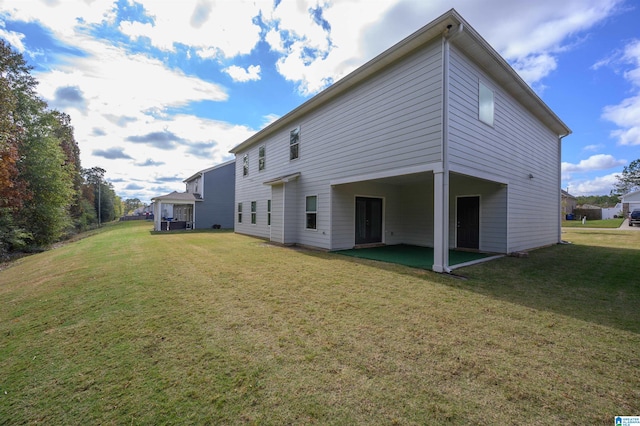 rear view of house featuring a patio area and a yard