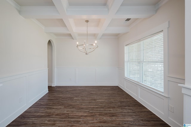 unfurnished dining area featuring an inviting chandelier, coffered ceiling, ornamental molding, dark hardwood / wood-style floors, and beam ceiling