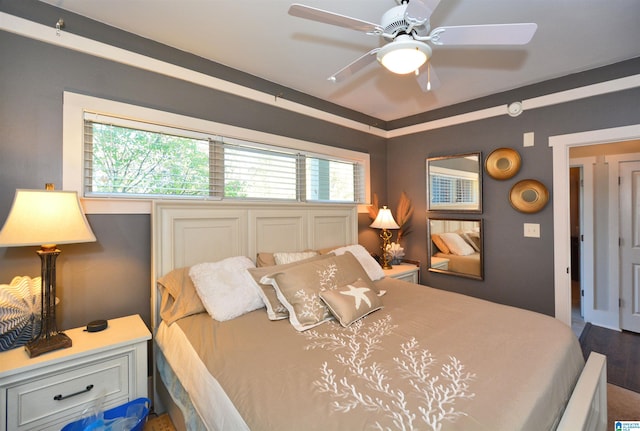 bedroom with ceiling fan, multiple windows, and wood-type flooring