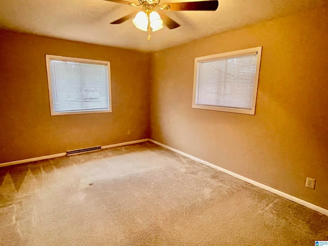 carpeted spare room with ceiling fan and a healthy amount of sunlight