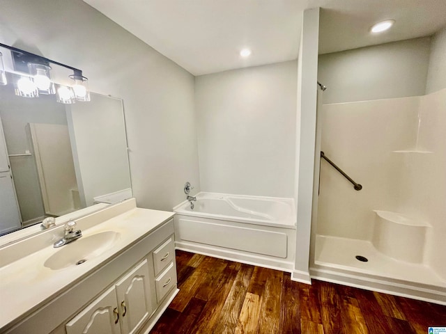 bathroom with a washtub, vanity, and hardwood / wood-style flooring