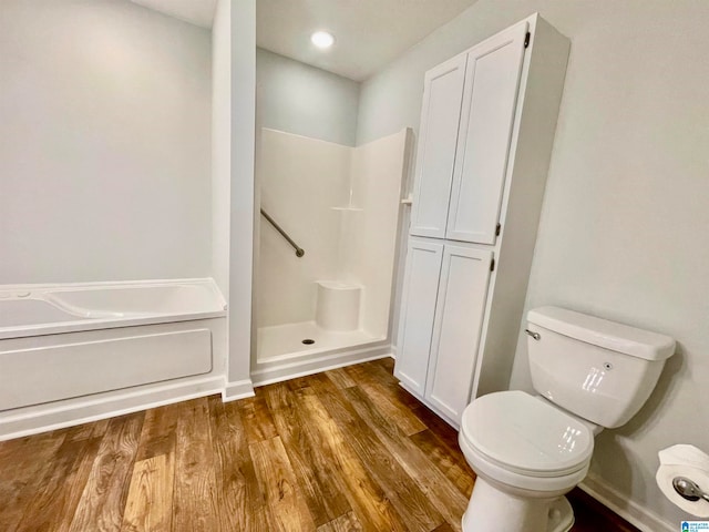 bathroom with hardwood / wood-style flooring, toilet, and a bathtub