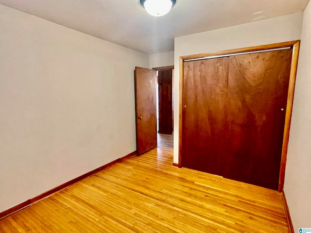 unfurnished bedroom featuring light wood-type flooring and a closet