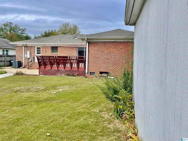 view of yard with central AC unit and a deck