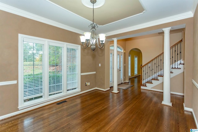 interior space featuring decorative columns, a notable chandelier, dark hardwood / wood-style floors, and crown molding