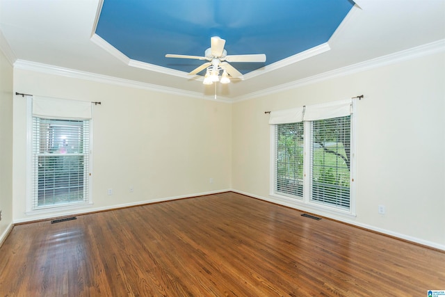 spare room with ceiling fan, wood-type flooring, a raised ceiling, and crown molding