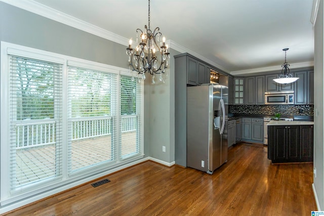 kitchen featuring gray cabinets, appliances with stainless steel finishes, hanging light fixtures, and dark hardwood / wood-style flooring