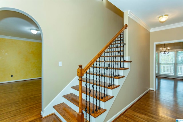 stairs with a chandelier, hardwood / wood-style flooring, and ornamental molding