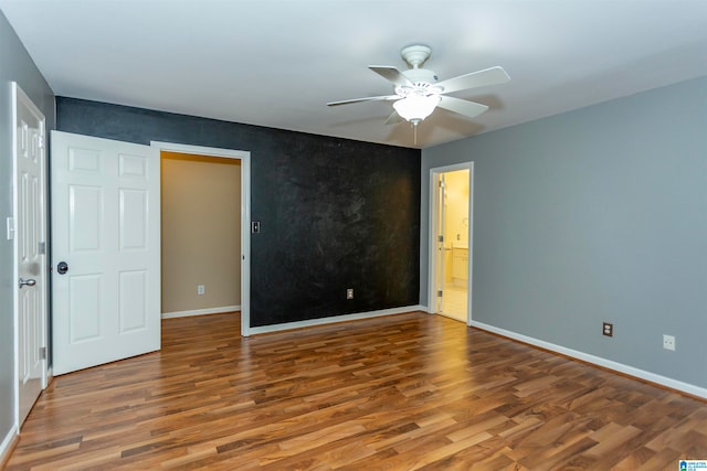 unfurnished bedroom featuring connected bathroom, hardwood / wood-style floors, and ceiling fan