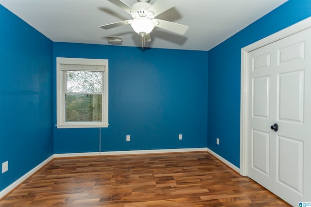 unfurnished bedroom with dark hardwood / wood-style flooring and ceiling fan