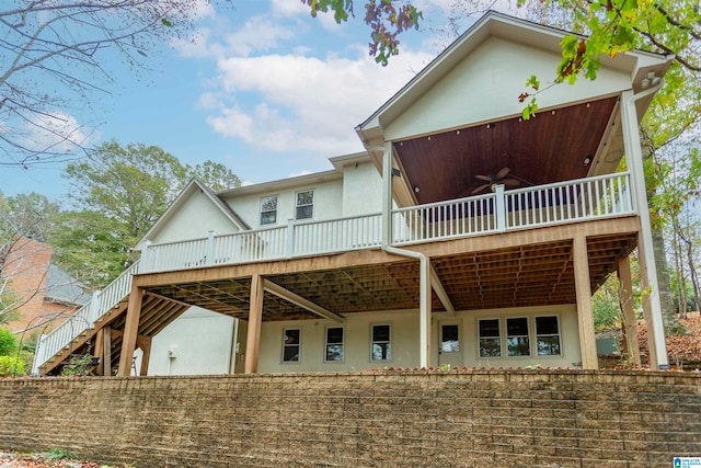 rear view of house featuring ceiling fan and a deck