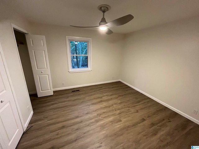 unfurnished bedroom with a closet, ceiling fan, and dark wood-type flooring