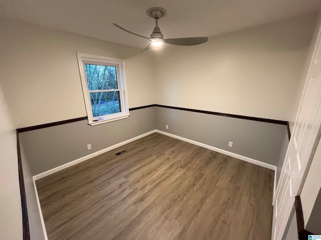 spare room with ceiling fan and dark wood-type flooring