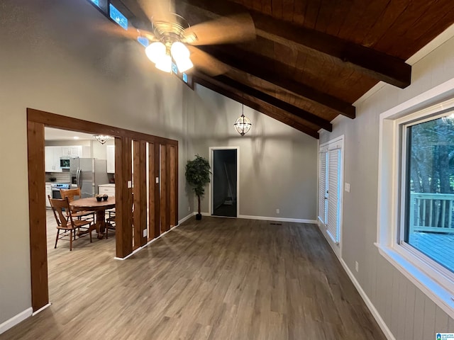 unfurnished living room with vaulted ceiling with beams, hardwood / wood-style flooring, ceiling fan, and wood ceiling