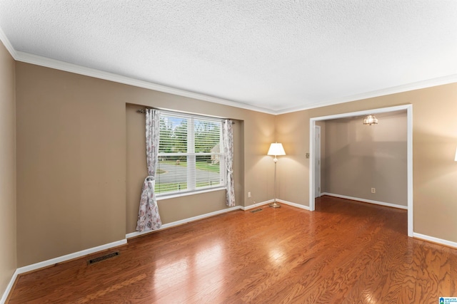 spare room with wood-type flooring, a textured ceiling, and crown molding