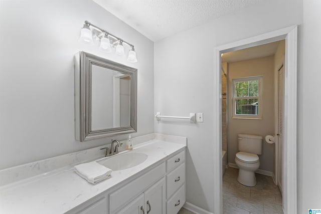 bathroom with vanity, toilet, and a textured ceiling