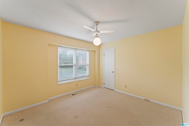 carpeted empty room featuring ceiling fan and a textured ceiling