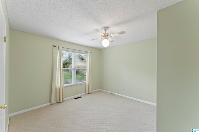 carpeted empty room featuring ceiling fan and a textured ceiling