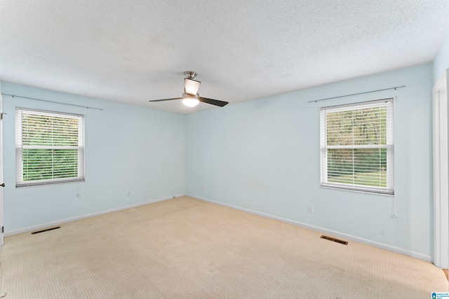 carpeted spare room with ceiling fan and a textured ceiling