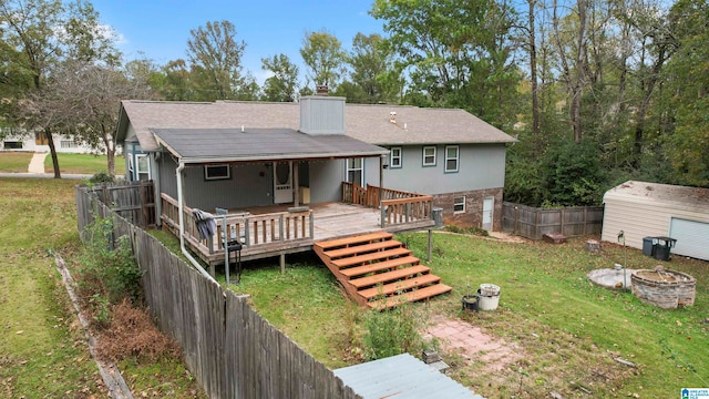 rear view of house featuring a storage unit, a yard, and a wooden deck