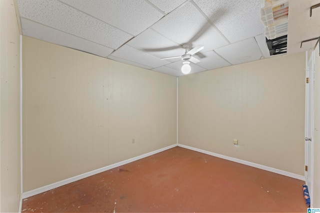 unfurnished room featuring a paneled ceiling, ceiling fan, and concrete flooring