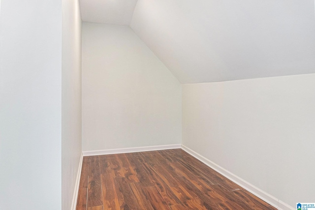 additional living space featuring dark hardwood / wood-style flooring and vaulted ceiling