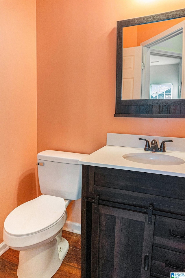 bathroom featuring hardwood / wood-style floors, vanity, and toilet