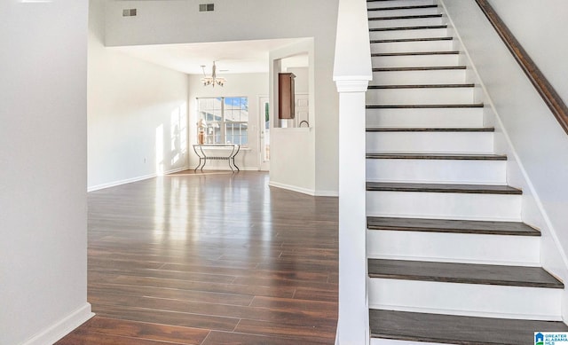 staircase with a chandelier and wood-type flooring