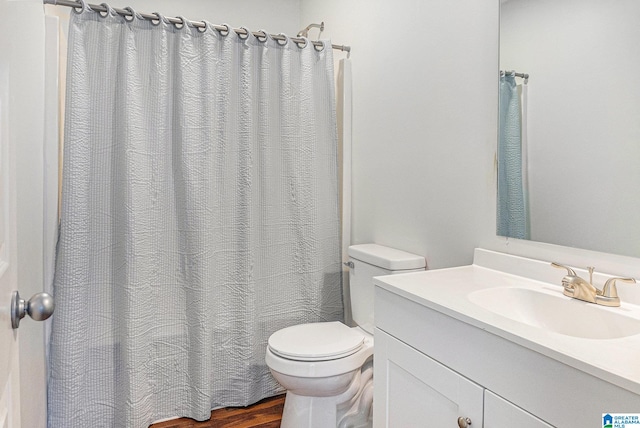 bathroom featuring wood-type flooring, vanity, and toilet