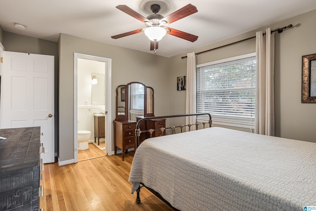 bedroom featuring light wood-type flooring, ceiling fan, and ensuite bath