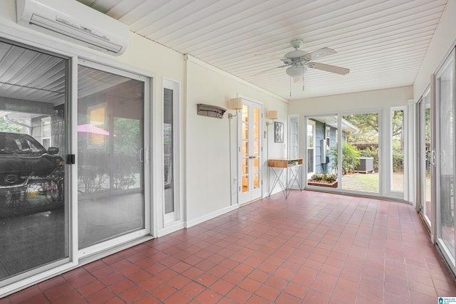 unfurnished sunroom with an AC wall unit, a healthy amount of sunlight, and ceiling fan