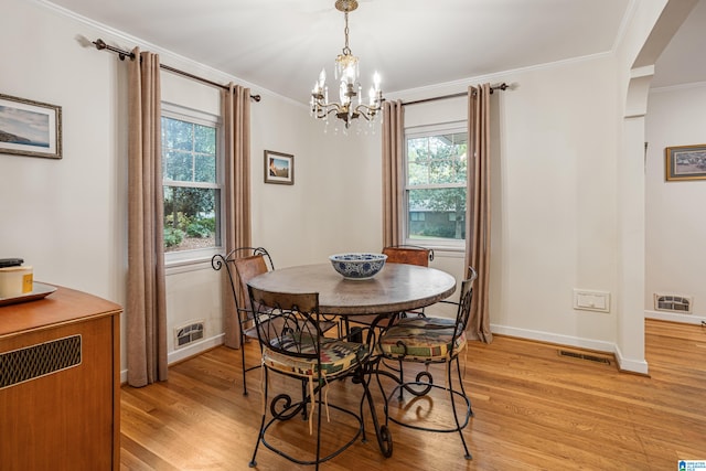 dining area featuring light hardwood / wood-style floors, a chandelier, and ornamental molding