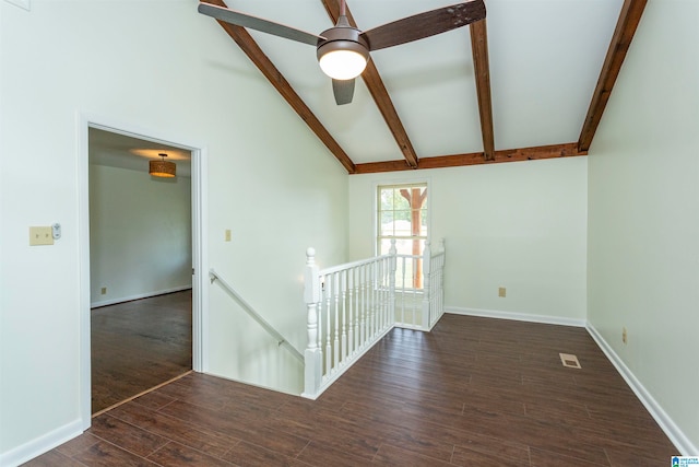 empty room featuring lofted ceiling with beams, ceiling fan, and dark hardwood / wood-style floors