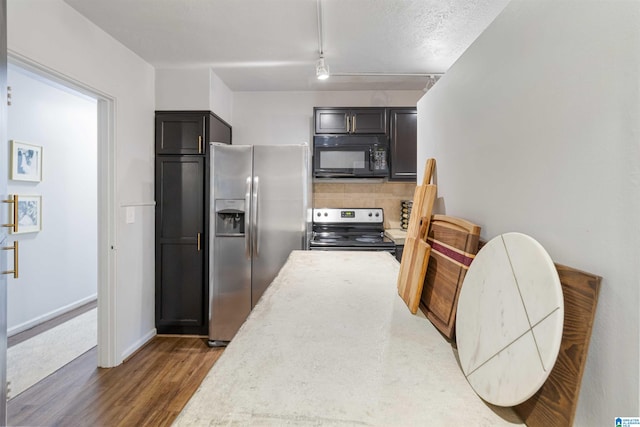 kitchen with a textured ceiling, track lighting, stainless steel appliances, and dark hardwood / wood-style floors