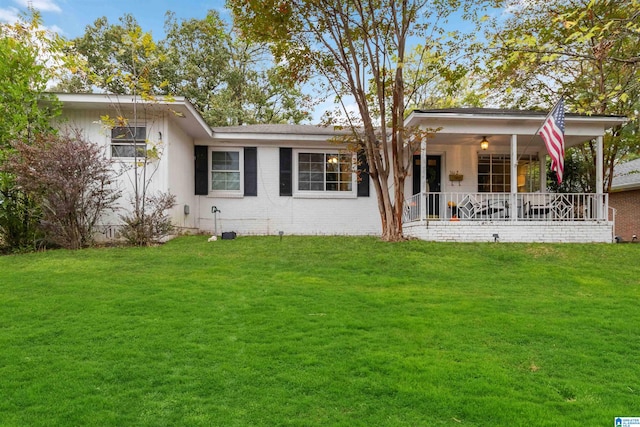 rear view of property featuring a porch and a yard