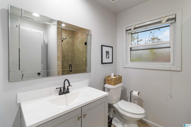 bathroom with a shower with door, vanity, and toilet