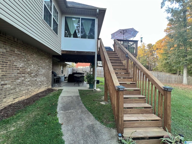 entrance to property with a lawn and a patio area