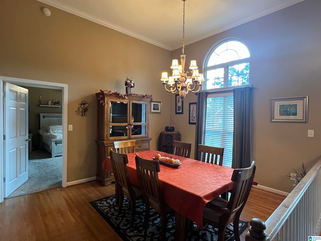 dining space featuring crown molding, an inviting chandelier, and hardwood / wood-style flooring