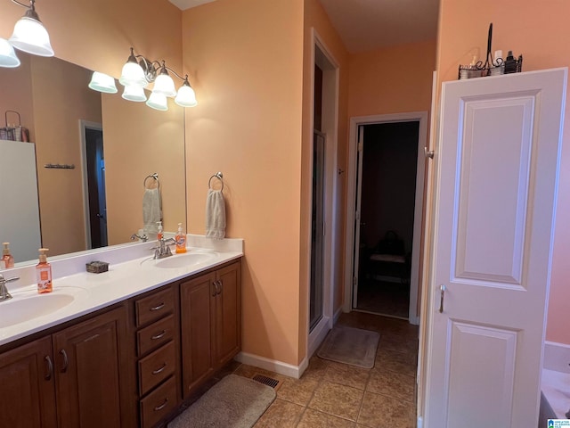 bathroom with an inviting chandelier, vanity, and a shower with door