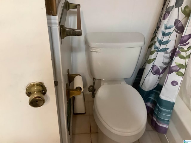 bathroom featuring toilet, tile patterned flooring, and curtained shower