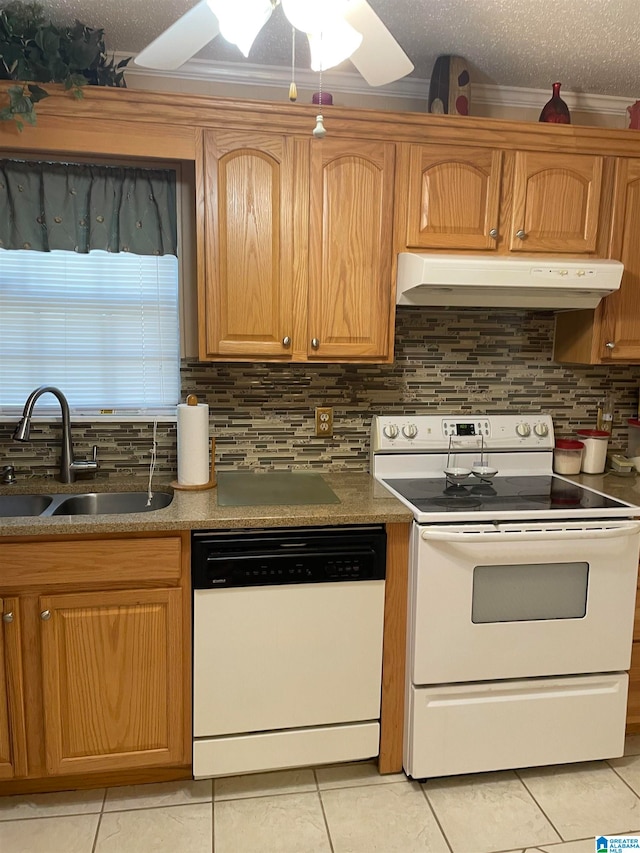 kitchen with white appliances, sink, light tile patterned floors, and a textured ceiling