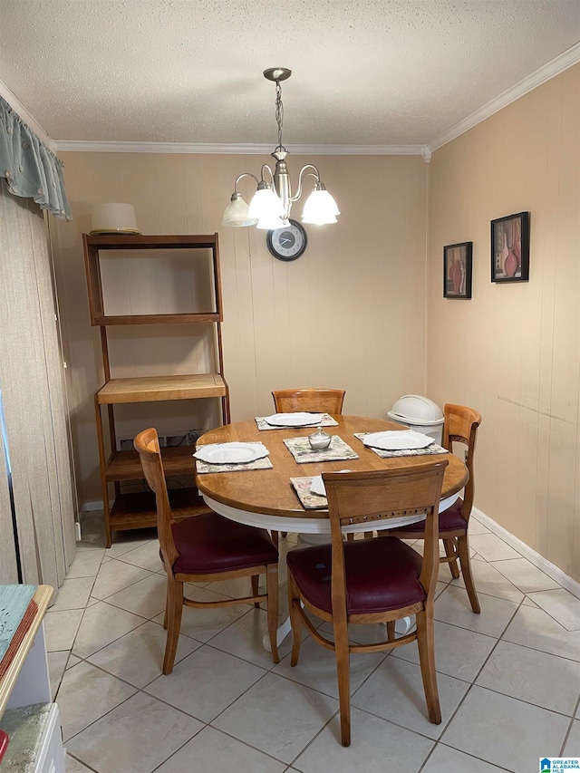 tiled dining room with a notable chandelier, a textured ceiling, crown molding, and wooden walls