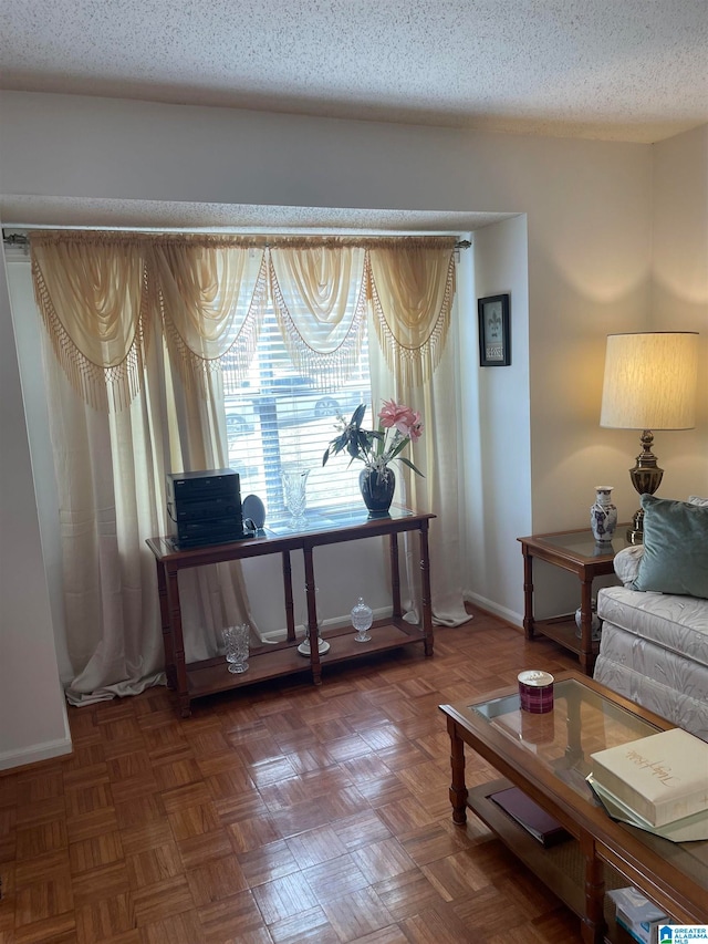 sitting room with a textured ceiling and dark parquet floors