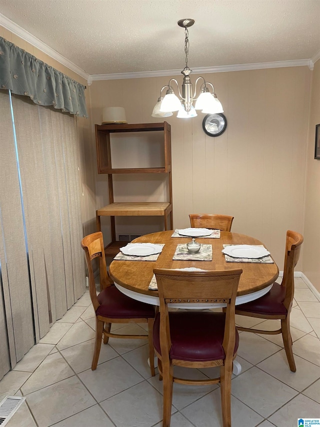 tiled dining space featuring a textured ceiling, wood walls, a chandelier, and crown molding