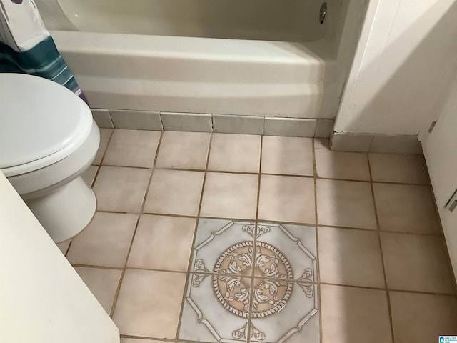 bathroom with tile patterned flooring, toilet, and a bathtub