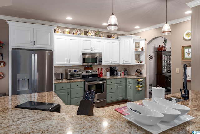 kitchen featuring white cabinets, hanging light fixtures, crown molding, and appliances with stainless steel finishes