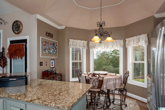 kitchen featuring pendant lighting, a wealth of natural light, wood-type flooring, and stainless steel refrigerator