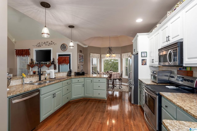 kitchen featuring stainless steel appliances, white cabinetry, an inviting chandelier, hanging light fixtures, and dark wood-type flooring